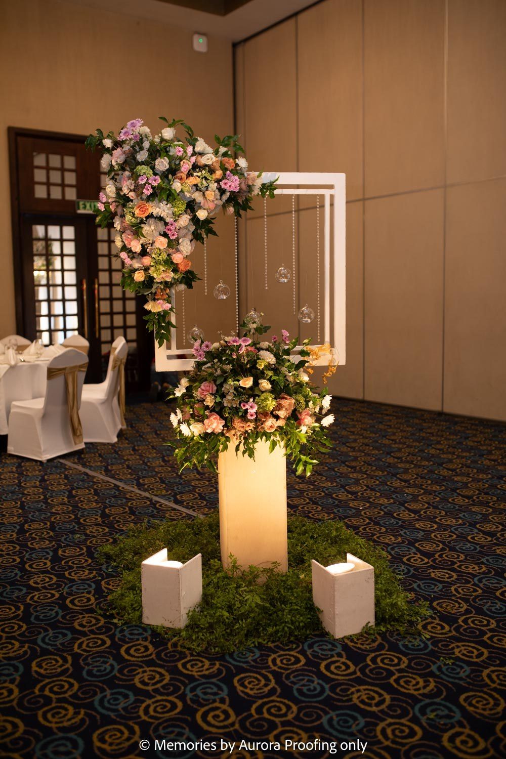 Lit pillar entrance with floral arrangement