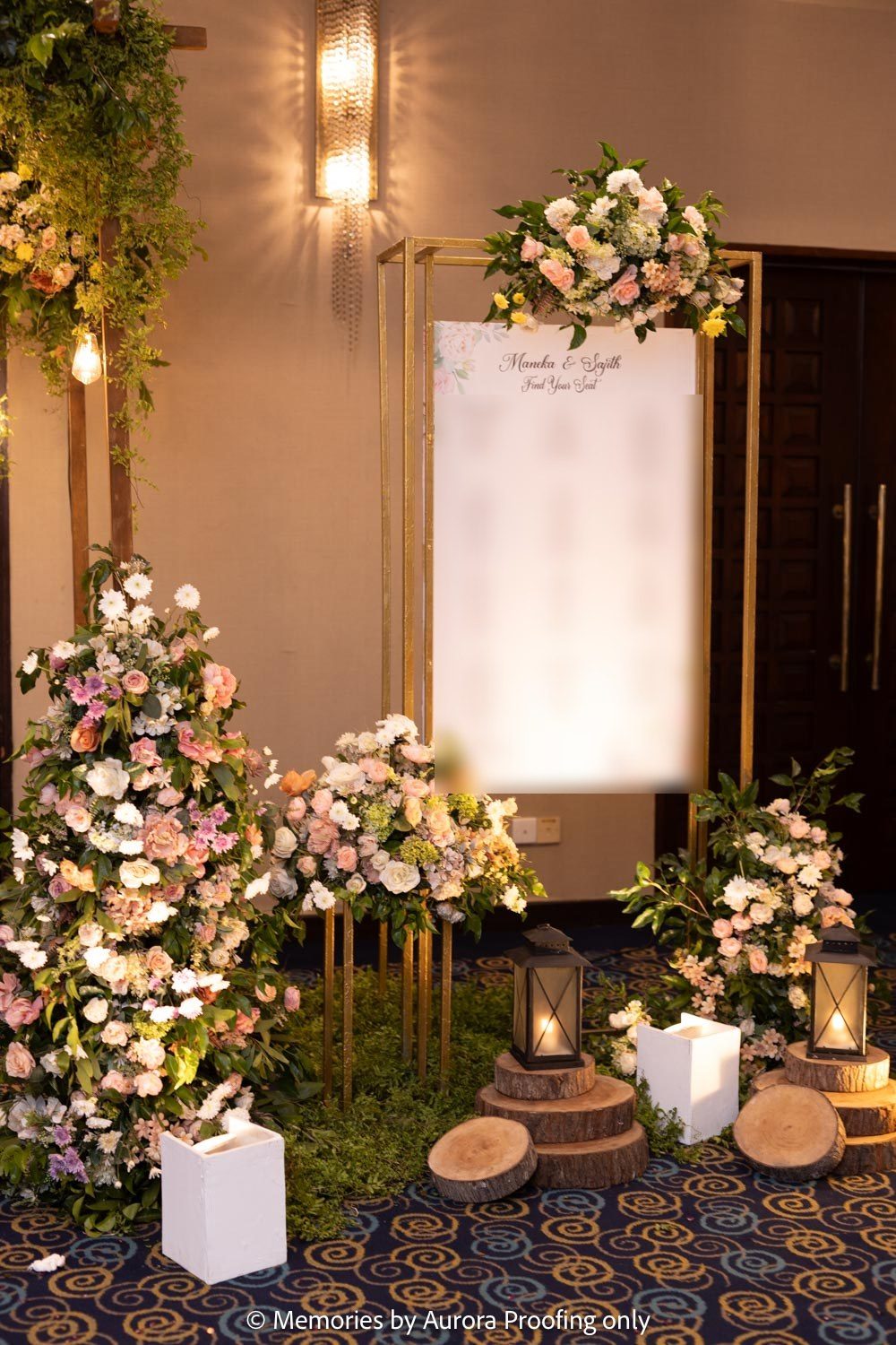Seating plan board framed with florals and lanterns (names blurred)