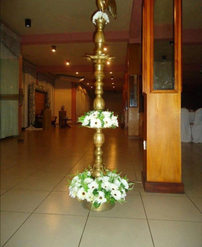 Brass oil lamp dressed with white gerberas