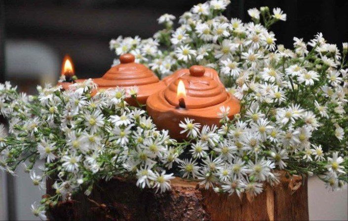 Clay oil lamps surrounded by white daisies