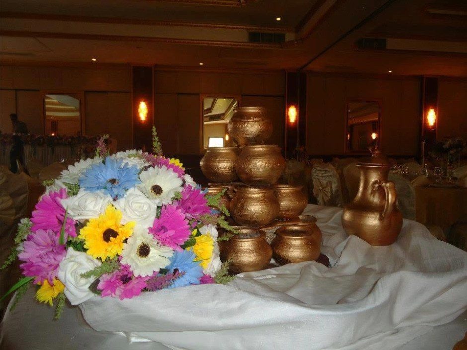 Milk fountain with brass pots and fresh flowers